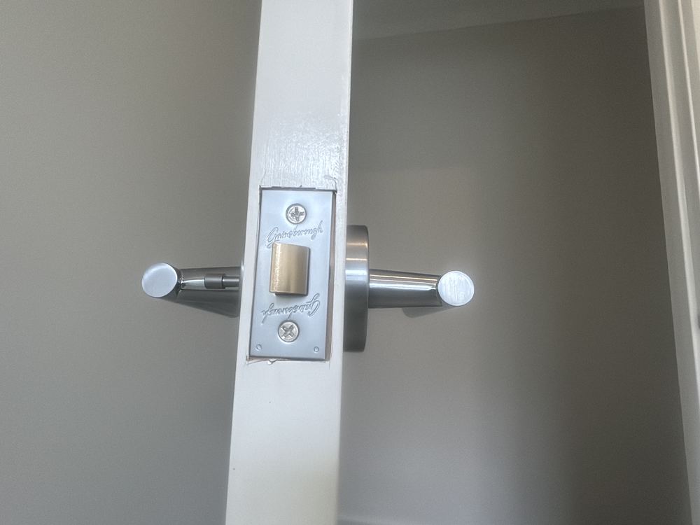 Area around the bathroom door latch needing filling and painting, found during a pre-handover inspection in Wollert