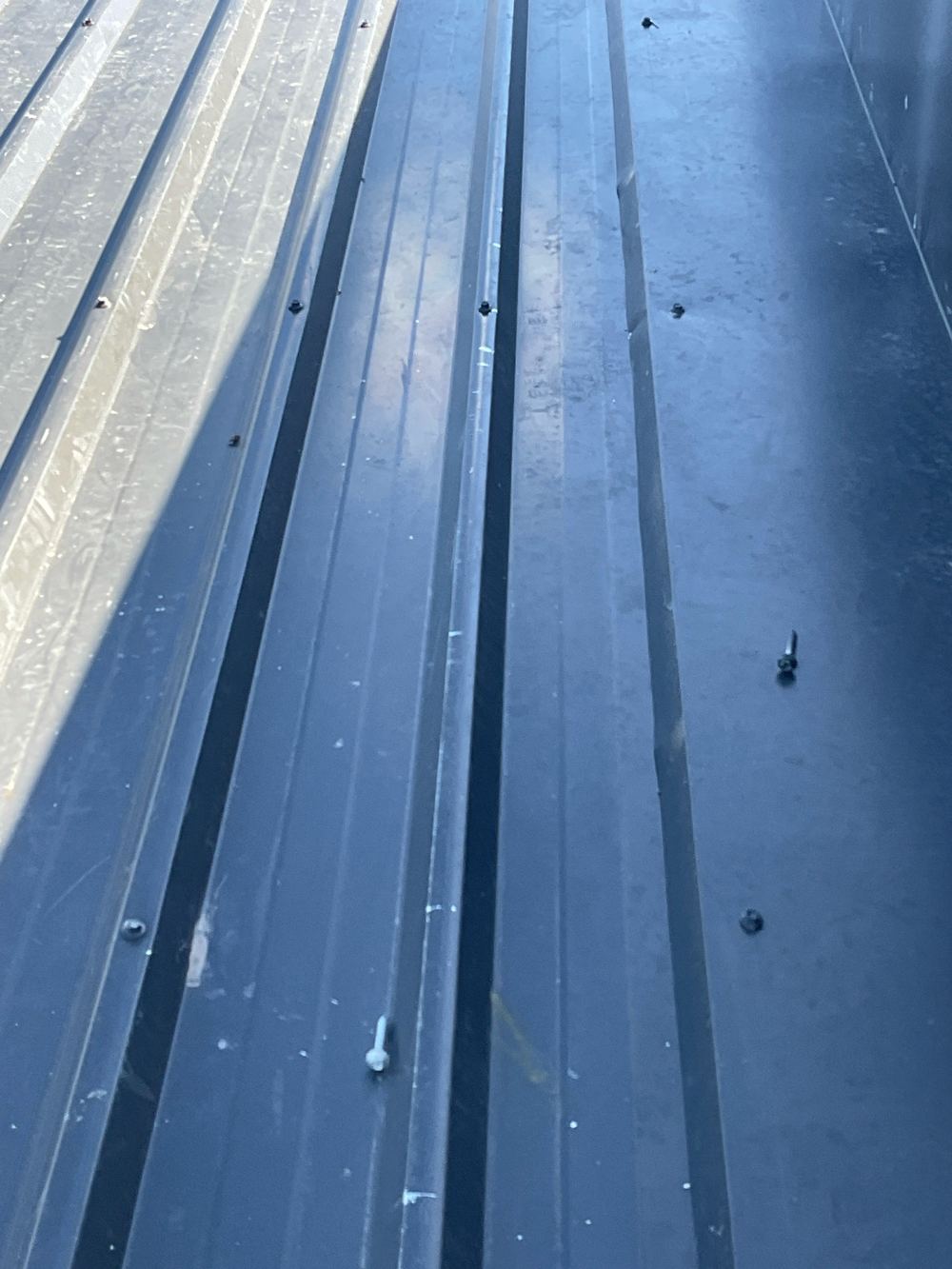 Debris left on the metal roof that needs clearing before handover, found during a construction stage inspection in Wollert